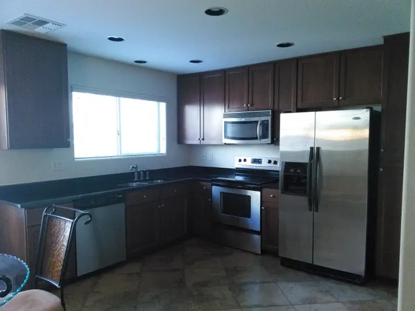 a kitchen with granite countertop a refrigerator and a sink