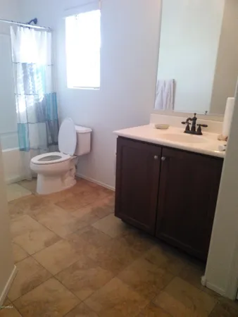 a bathroom with a sink vanity mirror and toilet