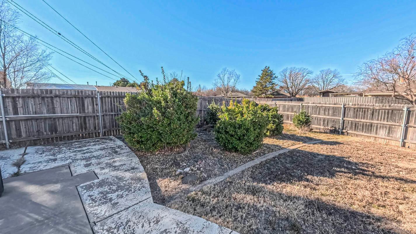 5015 Southwest 53rd Avenue Amarillo, TX 79109 - Photo 24 of 26 a view of a yard with plants and wooden fence