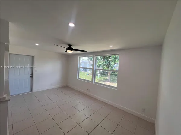 an empty room with windows and fan