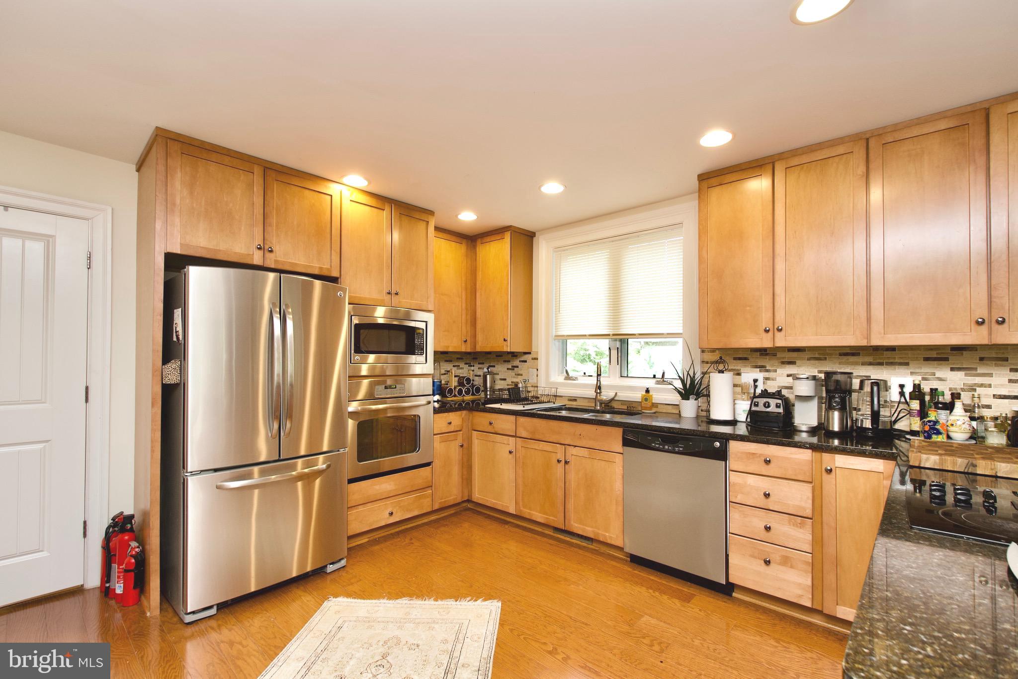 8312 Upper Spring Lane Annandale, VA 22003 - Photo 15 of 56 a kitchen with stainless steel appliances a refrigerator sink and cabinets