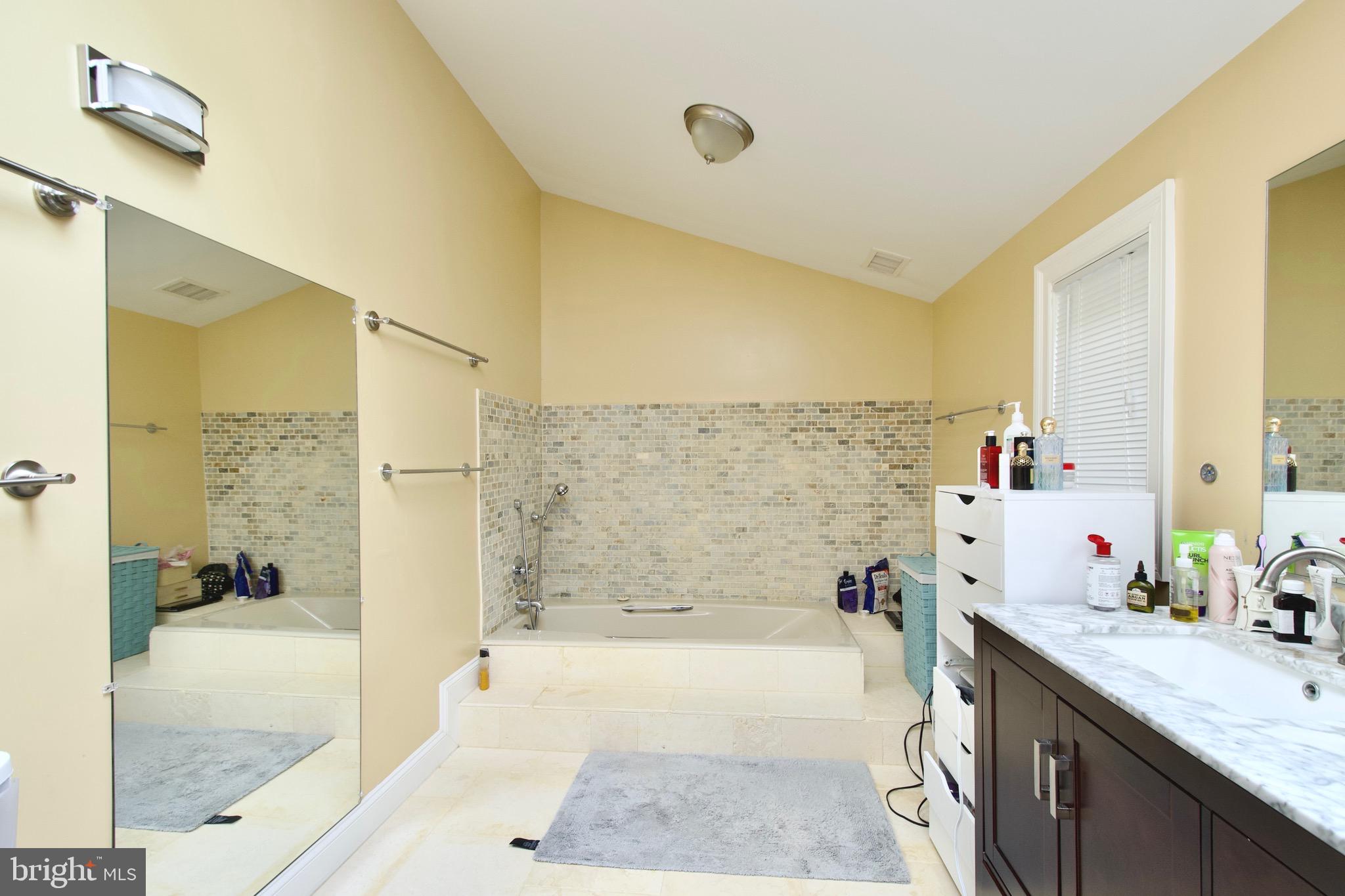8312 Upper Spring Lane Annandale, VA 22003 - Photo 21 of 56 a bathroom with a granite countertop bathtub a sink and a shower