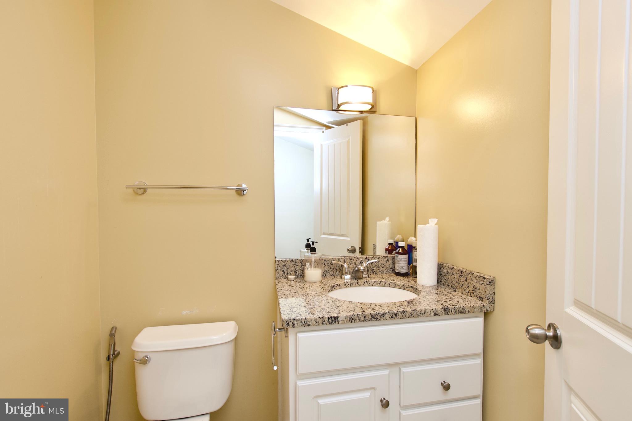 8312 Upper Spring Lane Annandale, VA 22003 - Photo 32 of 56 a bathroom with a granite countertop sink a toilet and a mirror