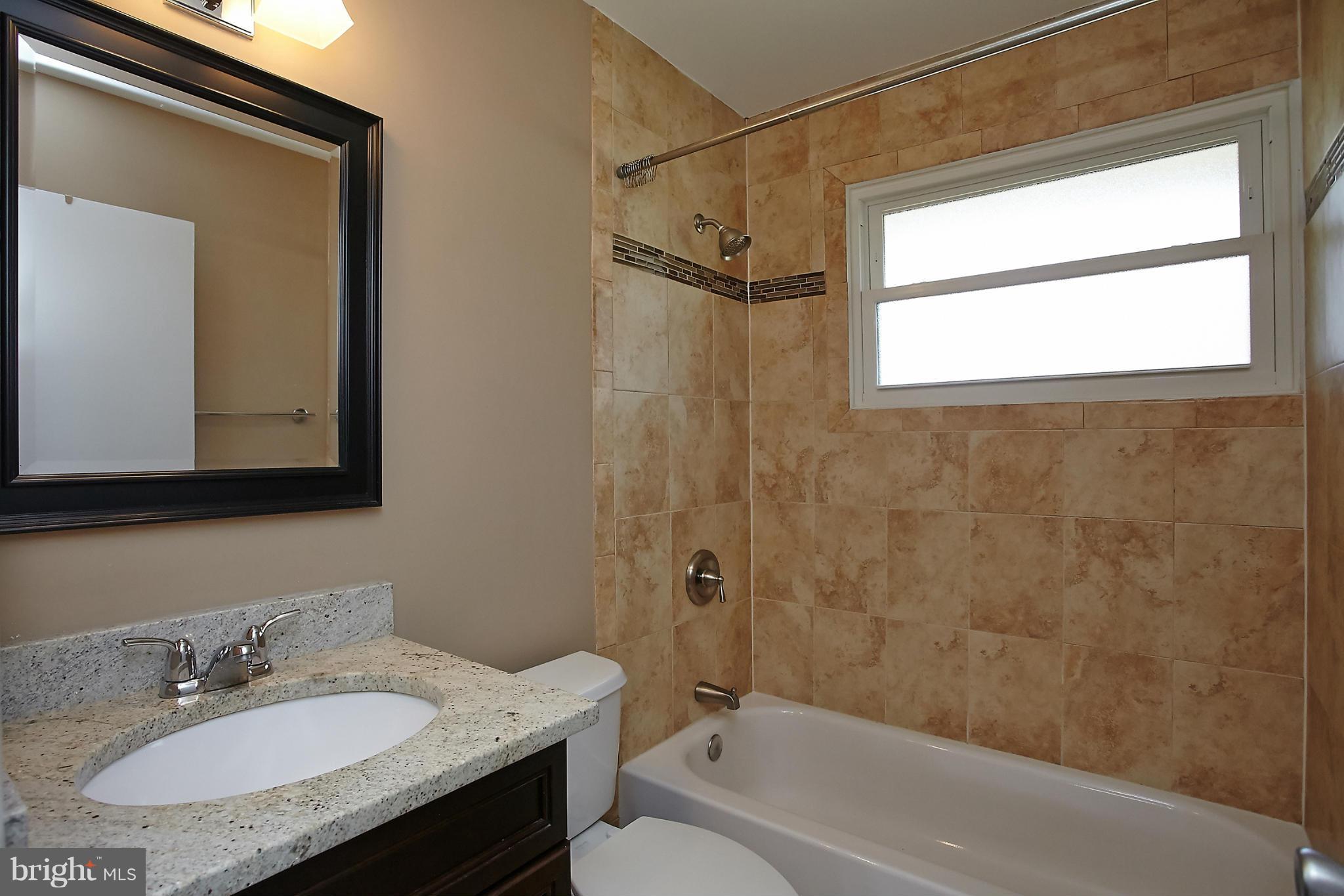 6717 Bostwick Drive Springfield, VA 22151 - Photo 9 of 12 a bathroom with a granite countertop sink toilet and shower