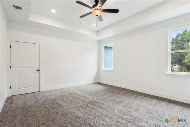 an empty room with fan and windows