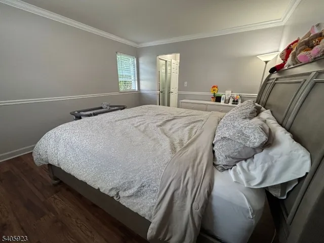 a bed sitting in a bedroom and wooden floor