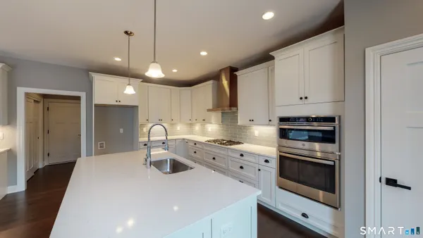 a kitchen with kitchen island a sink stainless steel appliances and cabinets