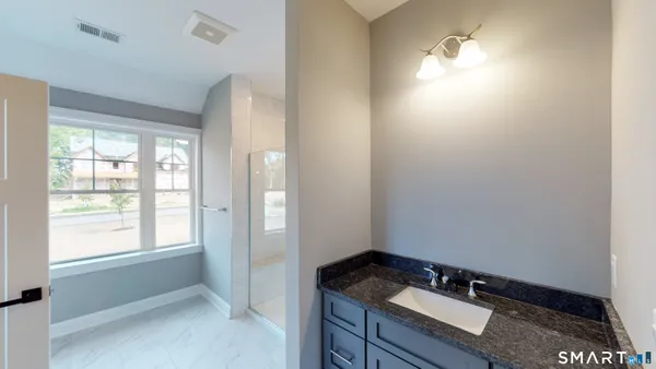 a bathroom with a sink vanity granite and a mirror