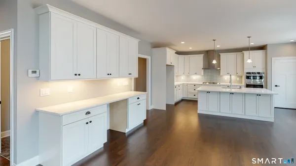 a large kitchen with stainless steel appliances granite countertop a lot of counter space and wooden floors