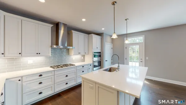 a kitchen with granite countertop white cabinets white appliances a sink and dishwasher