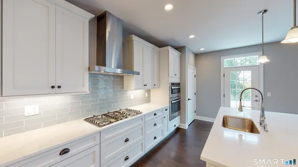 a kitchen with white cabinets and sink