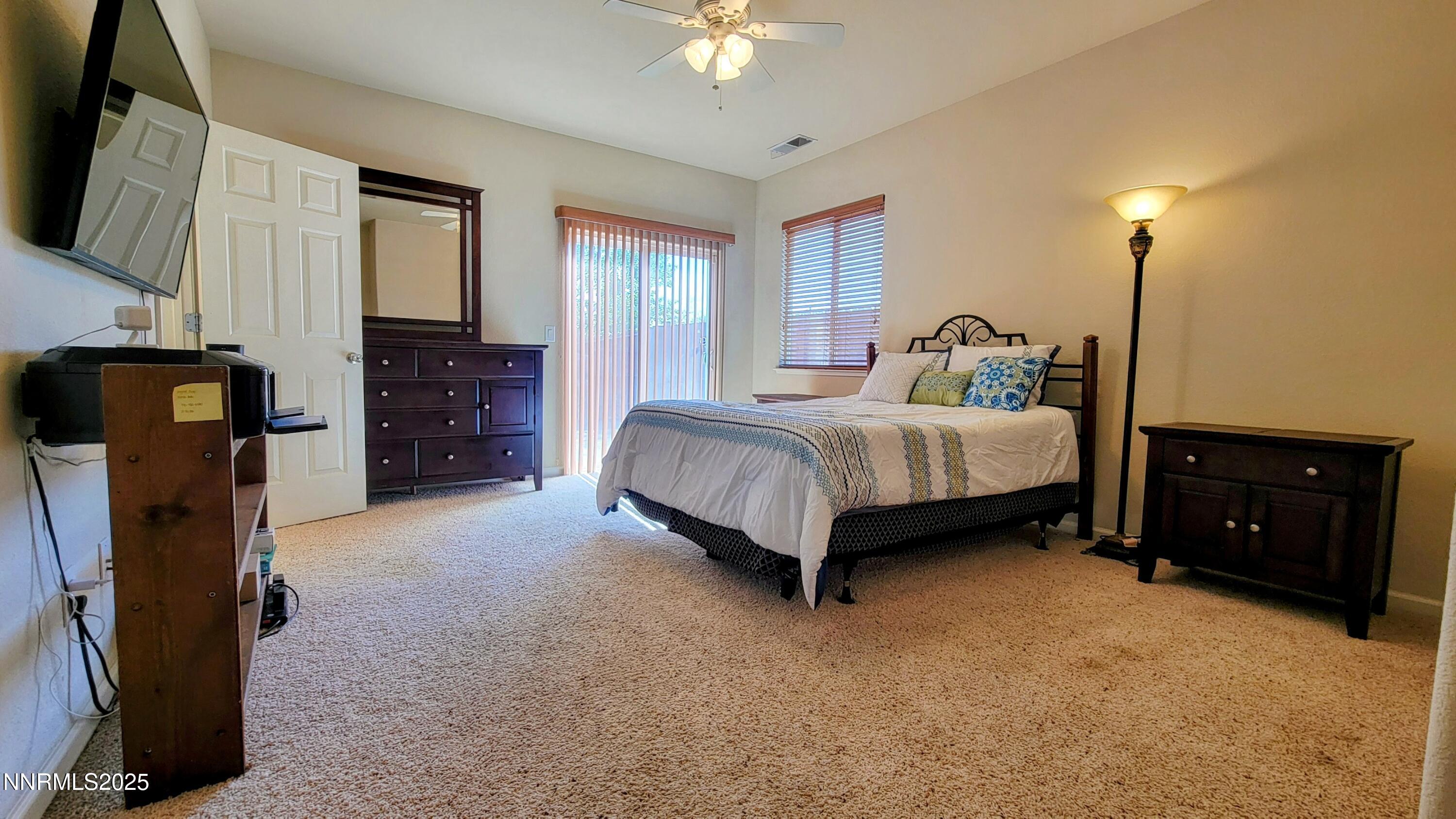 1390 Copper Leaf Drive Reno, NV 89506 - Photo 12 of 18 a spacious bedroom with a bed dresser and a flat tv screen