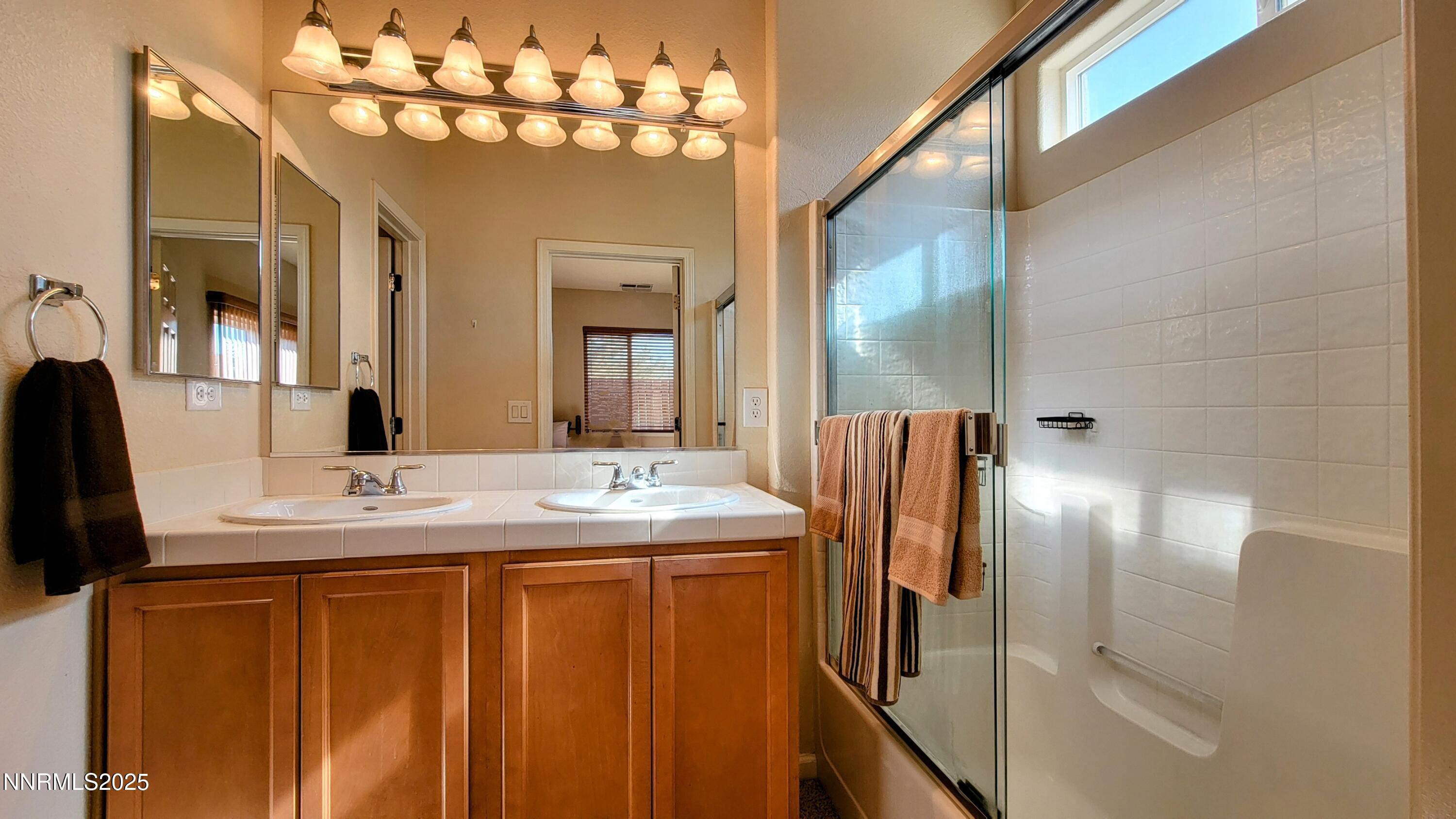 1390 Copper Leaf Drive Reno, NV 89506 - Photo 13 of 18 a bathroom with a double vanity sink and mirror
