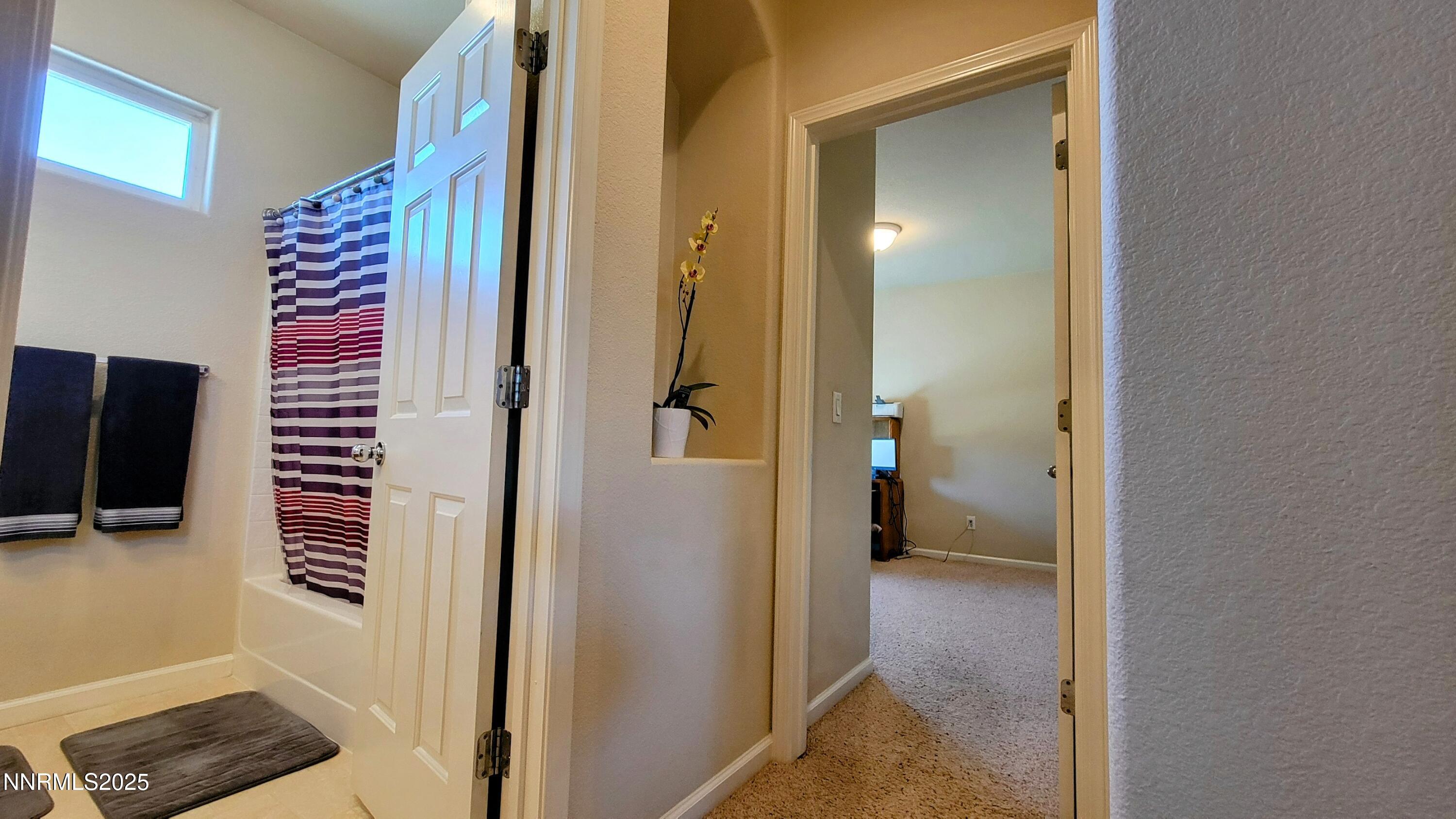 1390 Copper Leaf Drive Reno, NV 89506 - Photo 14 of 18 a view of a hallway with wooden floor and a bathroom
