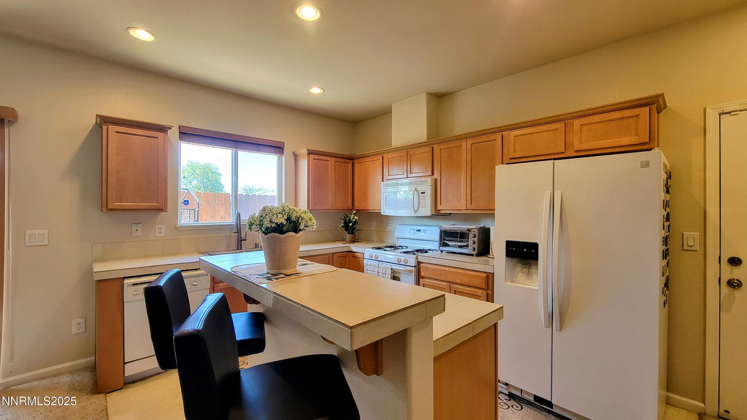 1390 Copper Leaf Drive Reno, NV 89506 - Photo 10 of 18 a kitchen that has a refrigerator a stove a table and chairs