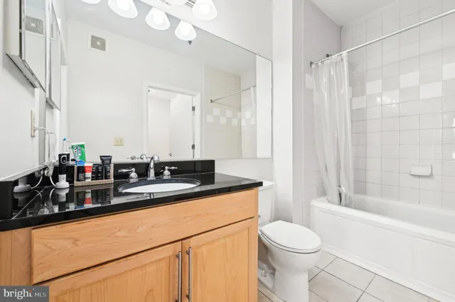 a bathroom with a granite countertop sink mirror vanity and toilet