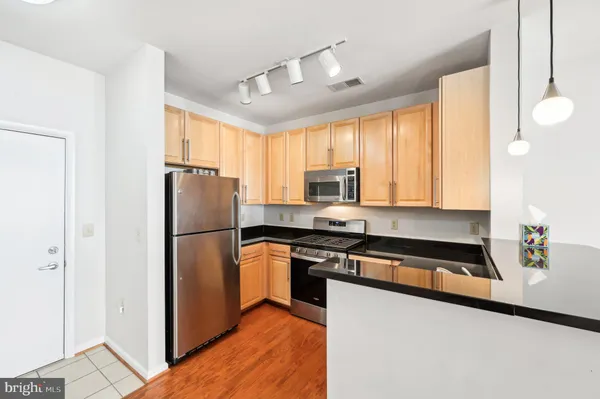 a kitchen with a refrigerator a stove cabinets and a window