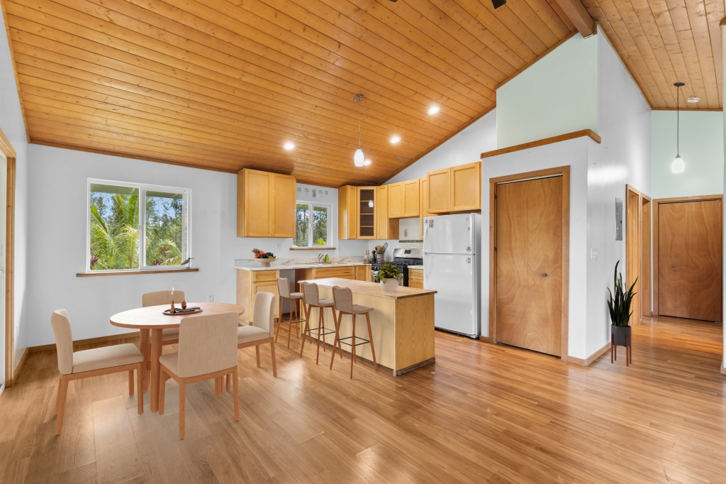 16-2103 Opeapea Road Mountain View, HI 96771 - Photo 6 of 30 a living room with stainless steel appliances kitchen island granite countertop furniture a dining table and chairs with wooden floor