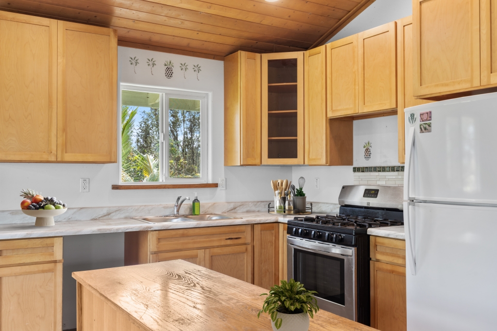 16-2103 Opeapea Road Mountain View, HI 96771 - Photo 7 of 30 a kitchen with stainless steel appliances granite countertop a sink stove and refrigerator