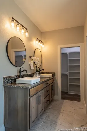 a bathroom with a granite countertop sink and a mirror