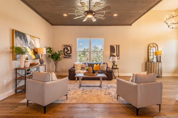 a living room with furniture or chandelier and a wooden floor