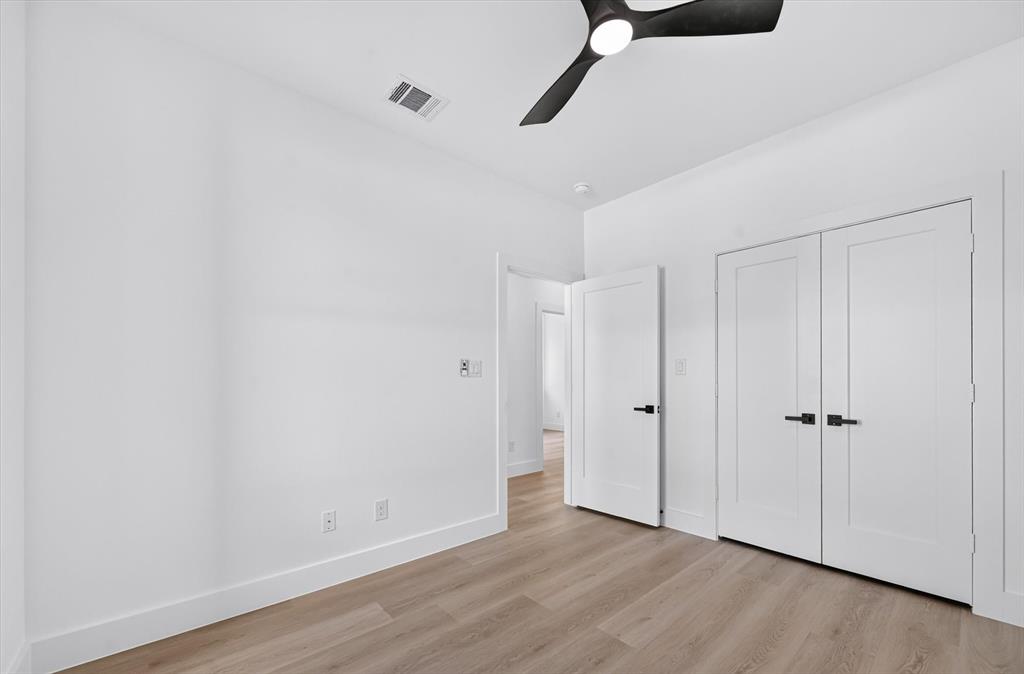 1632 West Wintergreen Road Lancaster, TX 75134 - Photo 23 of 30 Wood-finish flooring, white walls, and a modern ceiling fan