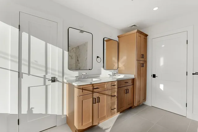 a spacious bathroom with a double vanity sink and a mirror