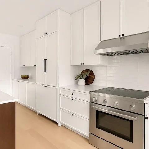 a kitchen with white cabinets and white appliances