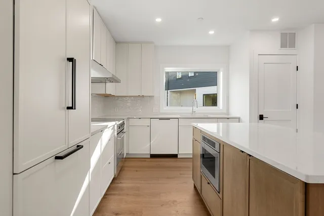 a kitchen with white cabinets and white appliances