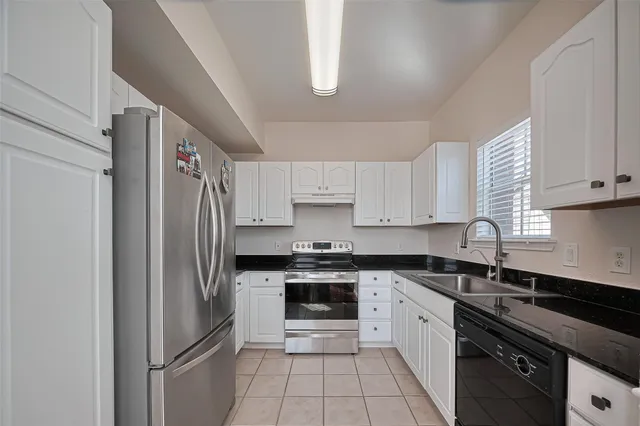 a kitchen with stainless steel appliances granite countertop a refrigerator sink and stove