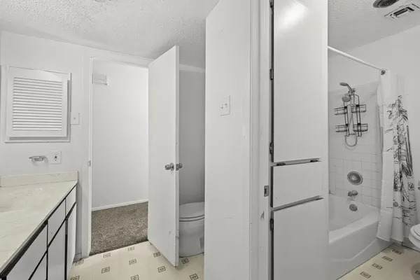 a bathroom with a granite countertop sink a toilet and shower