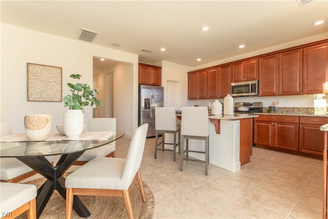 9779 Pachuca Reno, NV 89521 - Photo 3 of 16 a kitchen with kitchen island a dining table and chairs