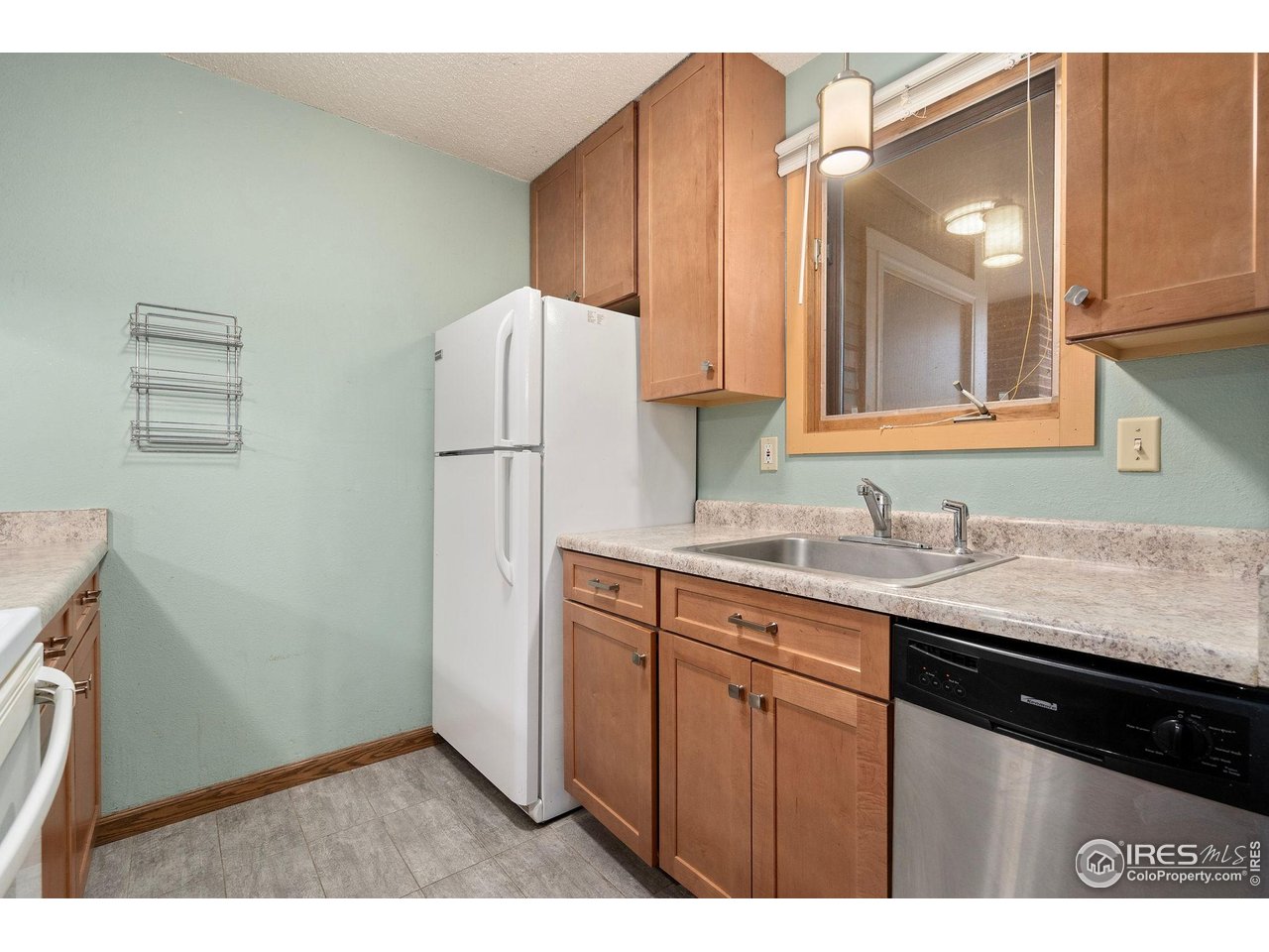 1213 West Swallow Road, Unit 213 Fort Collins, CO 80526 - Photo 14 of 24 a kitchen with a sink a refrigerator and cabinets