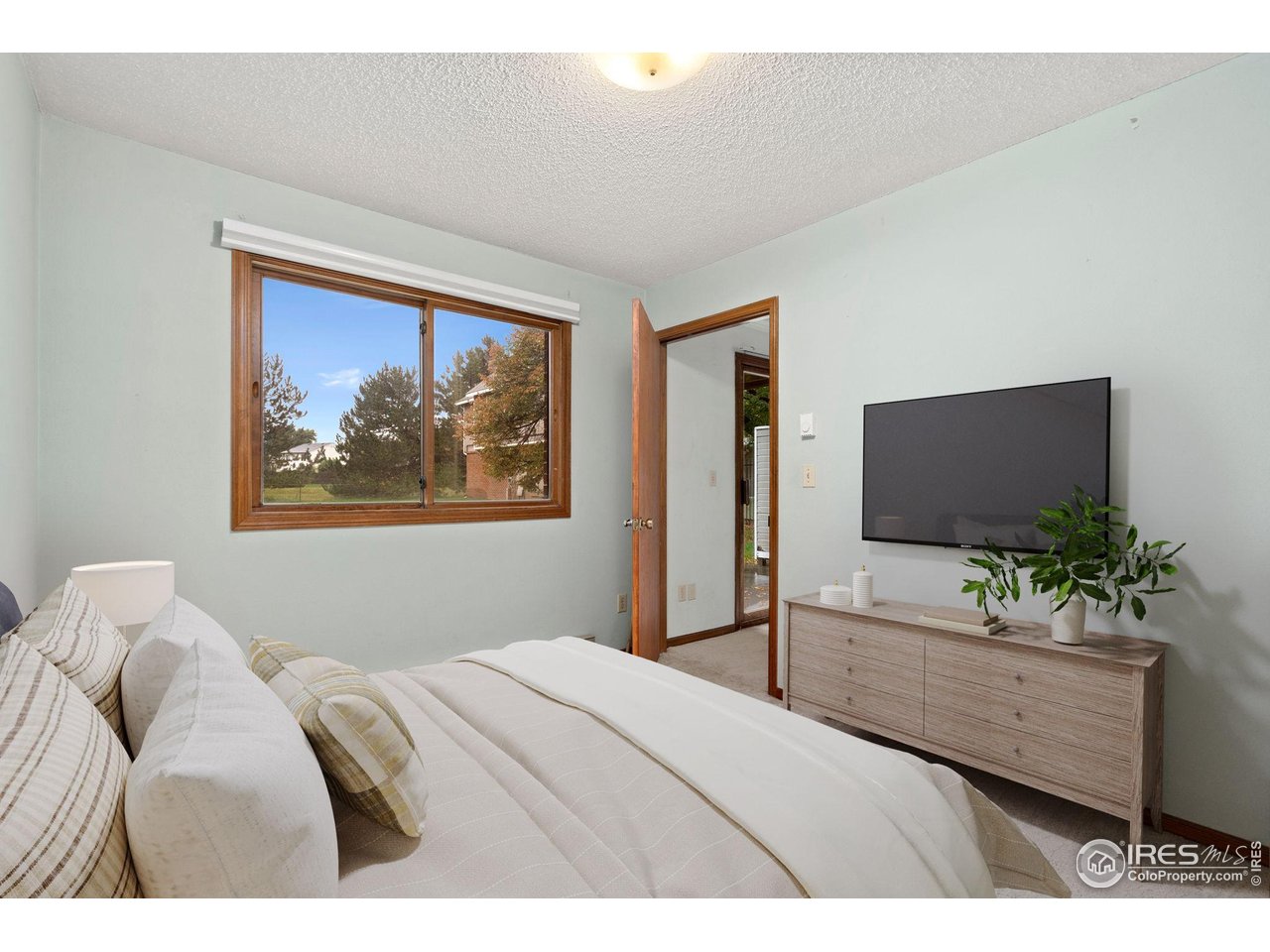 1213 West Swallow Road, Unit 213 Fort Collins, CO 80526 - Photo 15 of 24 a bedroom with a bed and a flat screen tv