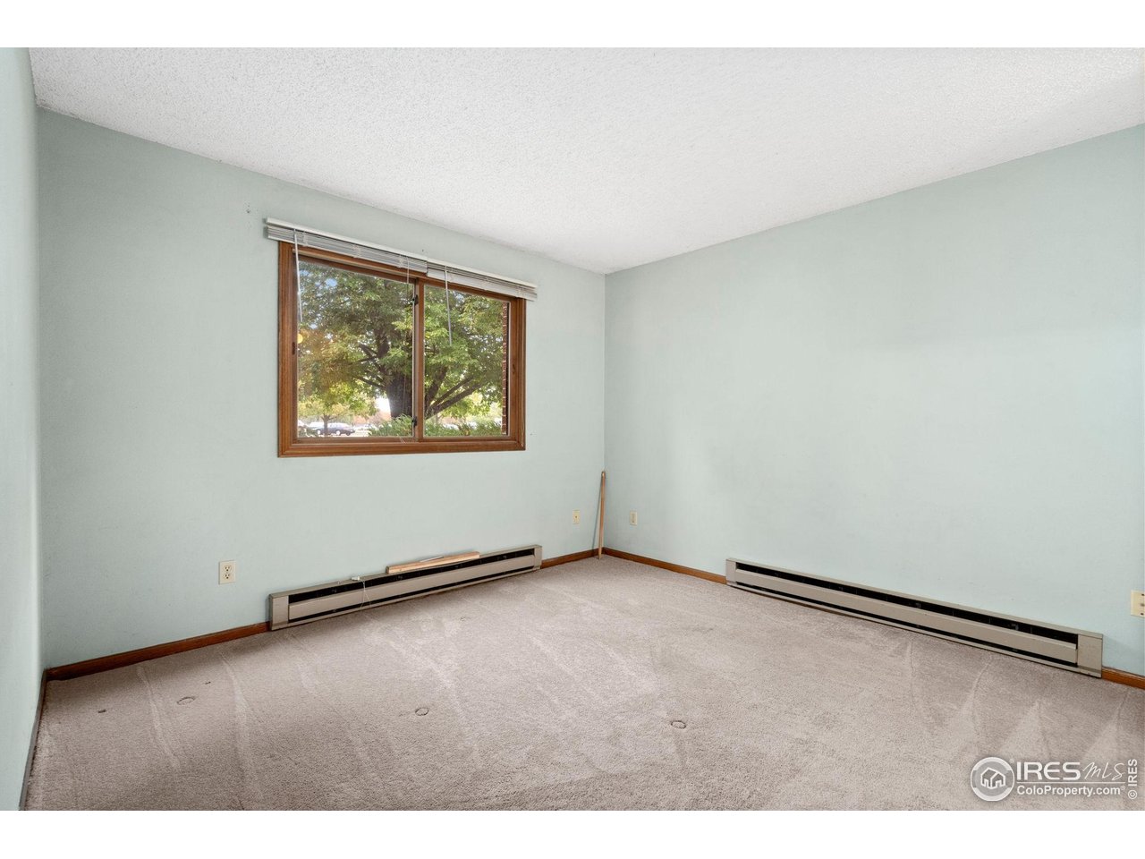 1213 West Swallow Road, Unit 213 Fort Collins, CO 80526 - Photo 19 of 24 an empty room with wooden floor and windows
