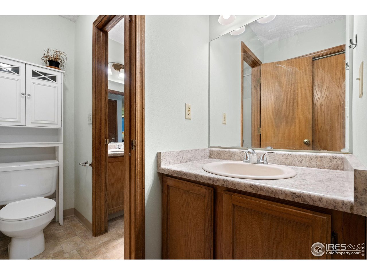 1213 West Swallow Road, Unit 213 Fort Collins, CO 80526 - Photo 21 of 24 a bathroom with a granite countertop sink toilet and mirror