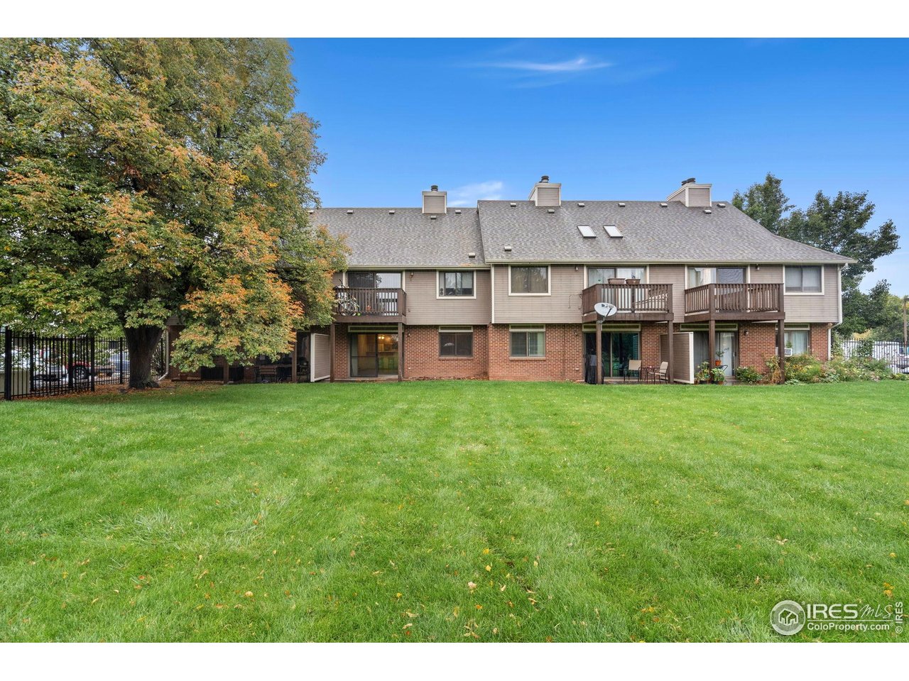 1213 West Swallow Road, Unit 213 Fort Collins, CO 80526 - Photo 24 of 24 a view of a big house with a big yard and large trees