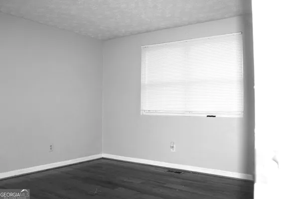 a view of a small space with wooden floor and a window