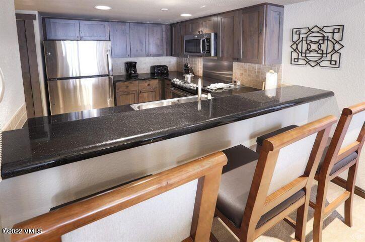 210 Offerson Road, Unit 11924 Beaver Creek, CO 81620 - Photo 5 of 16 a kitchen with a refrigerator and a sink