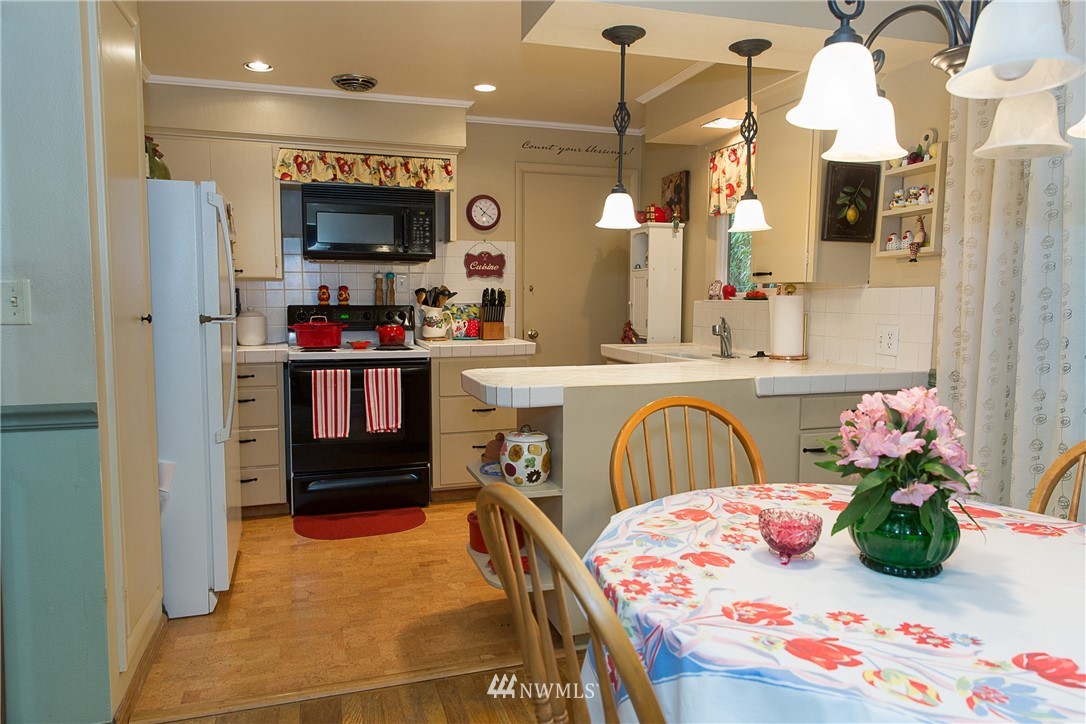 1419 18th Street Everett, WA 98201 - Photo 9 of 21 a kitchen with stainless steel appliances kitchen island granite countertop a table and chairs in it