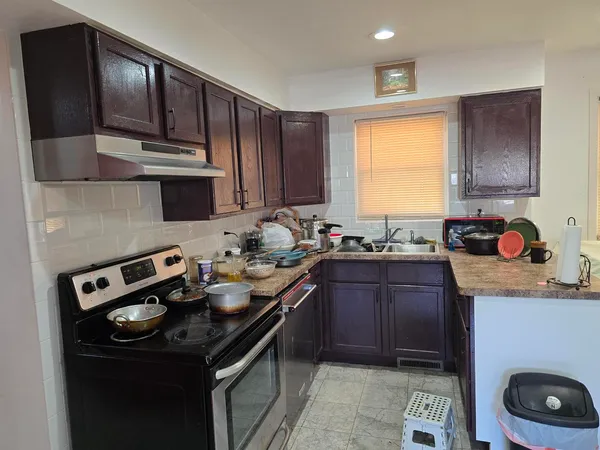 a kitchen with a sink a stove and cabinets