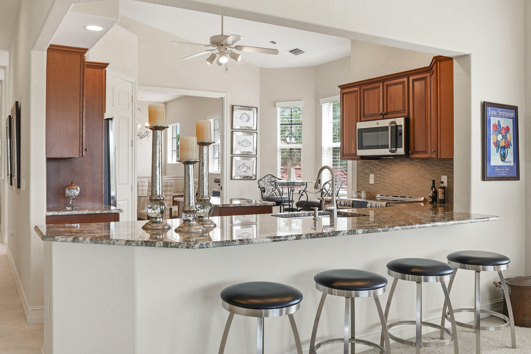8605 Champions Point, Unit 103 Naples, FL 34113 - Photo 15 of 44 a kitchen with stainless steel appliances granite countertop a kitchen island a stove and a sink