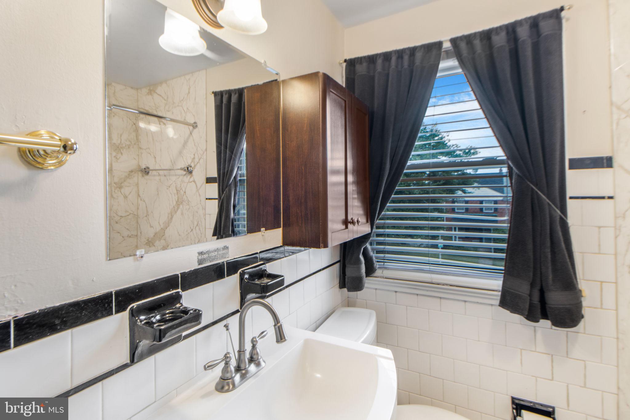 1903 Heathfield Road Baltimore, MD 21239 - Photo 20 of 30 a bathroom with a sink and a mirror