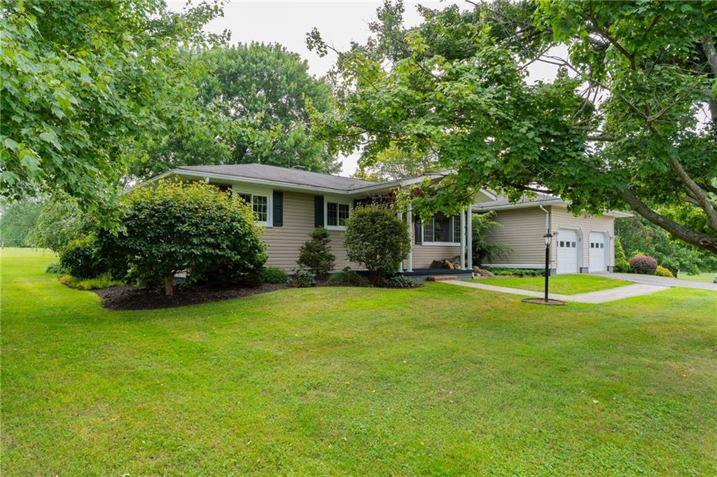 a view of a house with a yard and a tree