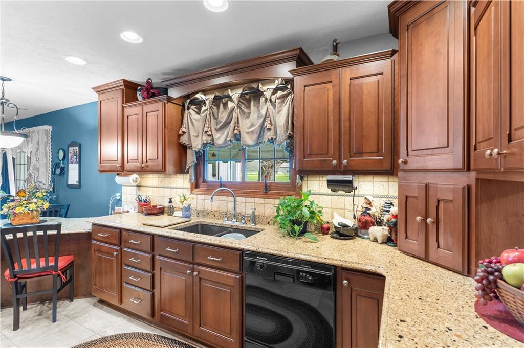 946 Crouser School Road Sandy Lake, PA 16145 - Photo 11 of 41 a kitchen with stainless steel appliances granite countertop a sink a stove and a wooden cabinets
