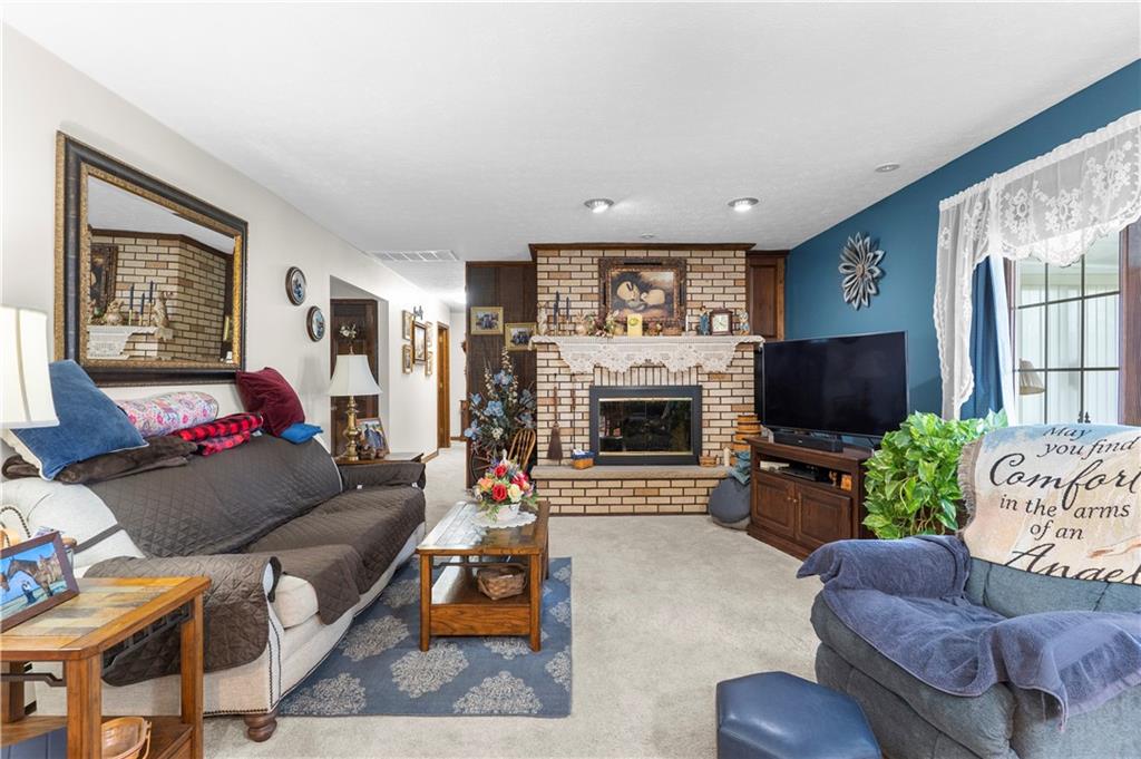 946 Crouser School Road Sandy Lake, PA 16145 - Photo 17 of 41 a living room with furniture a flat screen tv and a fireplace