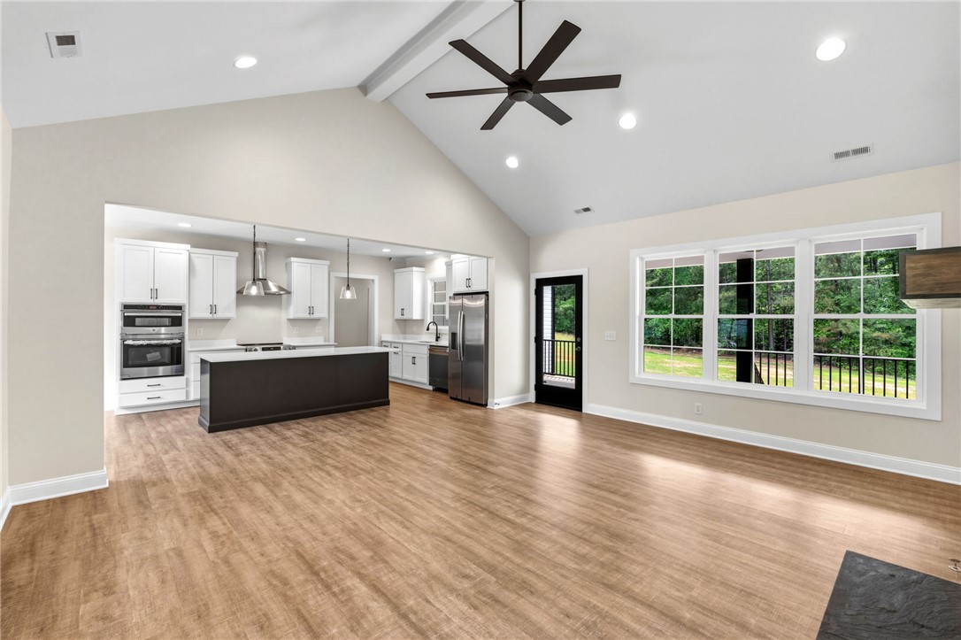 1735 Maw Bridge Road Central, SC 29630 - Photo 8 of 38 An open-concept living area seamlessly connects a modern kitchen and sun-drenched living space.