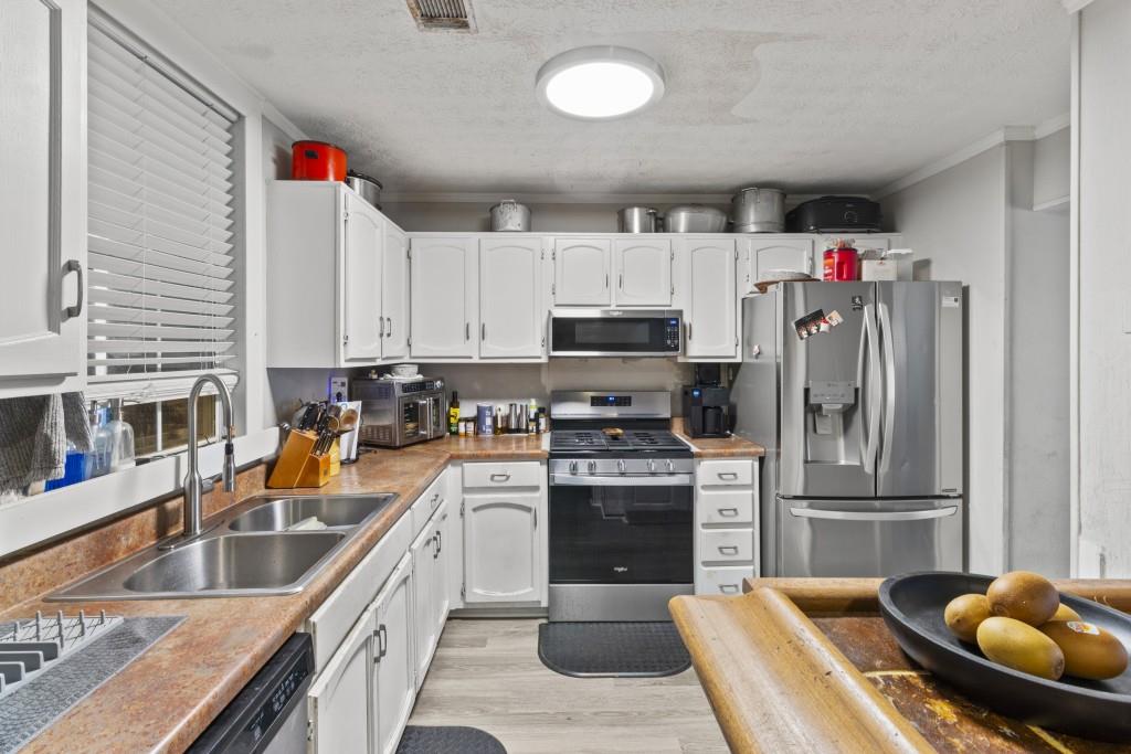 3509 Mt Vernon Circle Atlanta, GA 30340 - Photo 3 of 20 a kitchen with stainless steel appliances granite countertop a sink a stove and a refrigerator