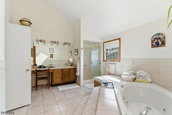 a bathroom with a tub sink and mirror