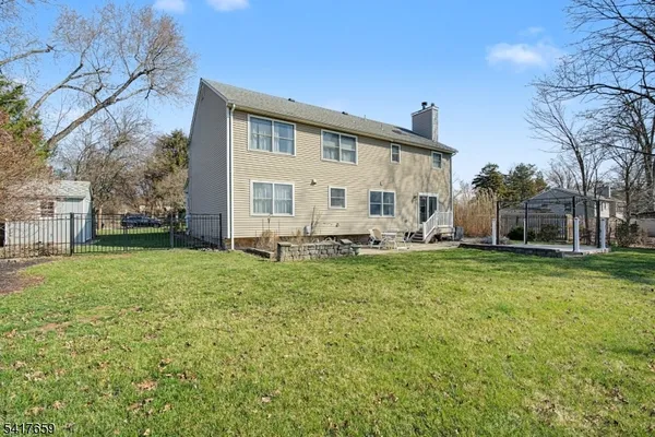 a view of a house with backyard and a tree